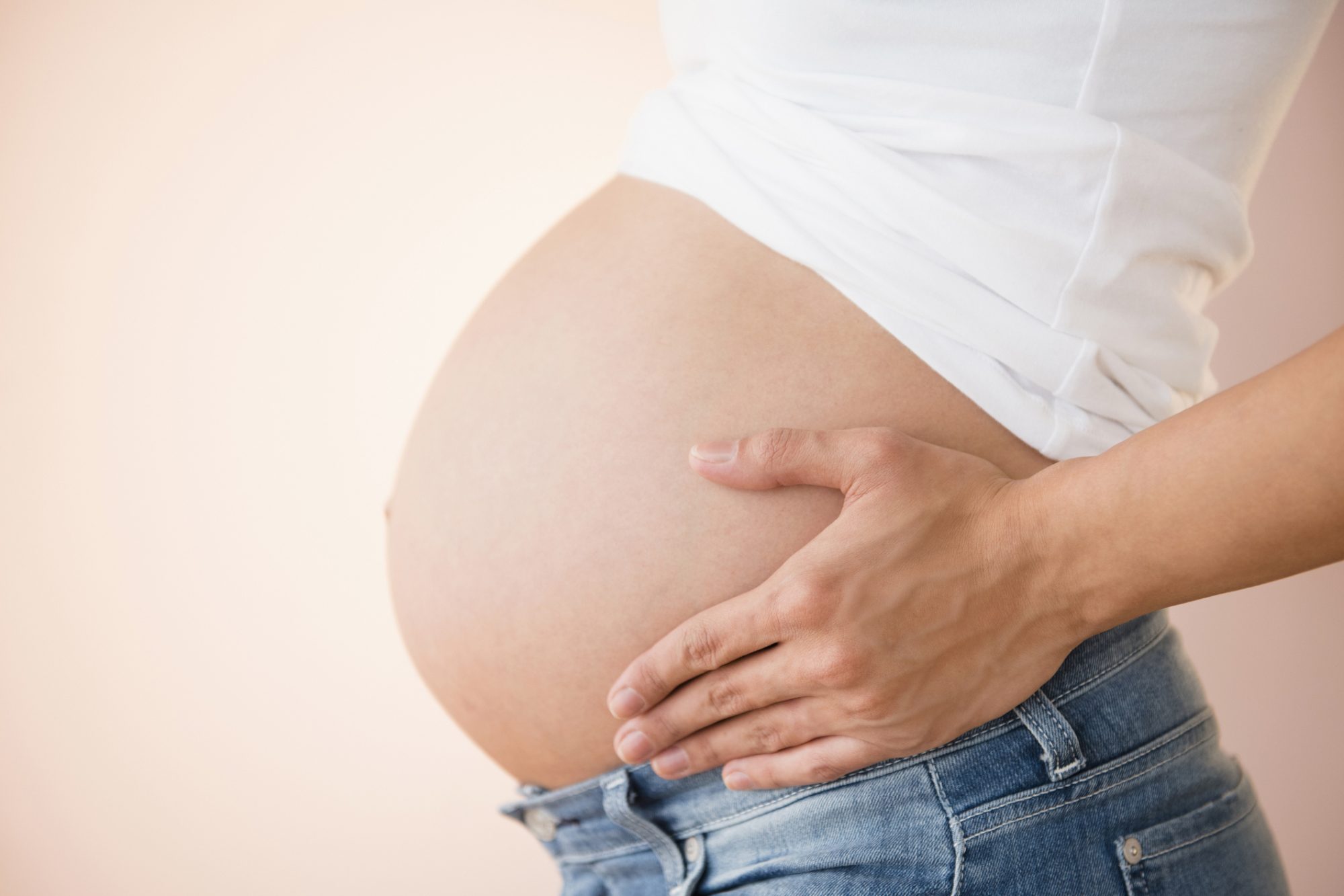 An image of a pregnant woman holding her belly.