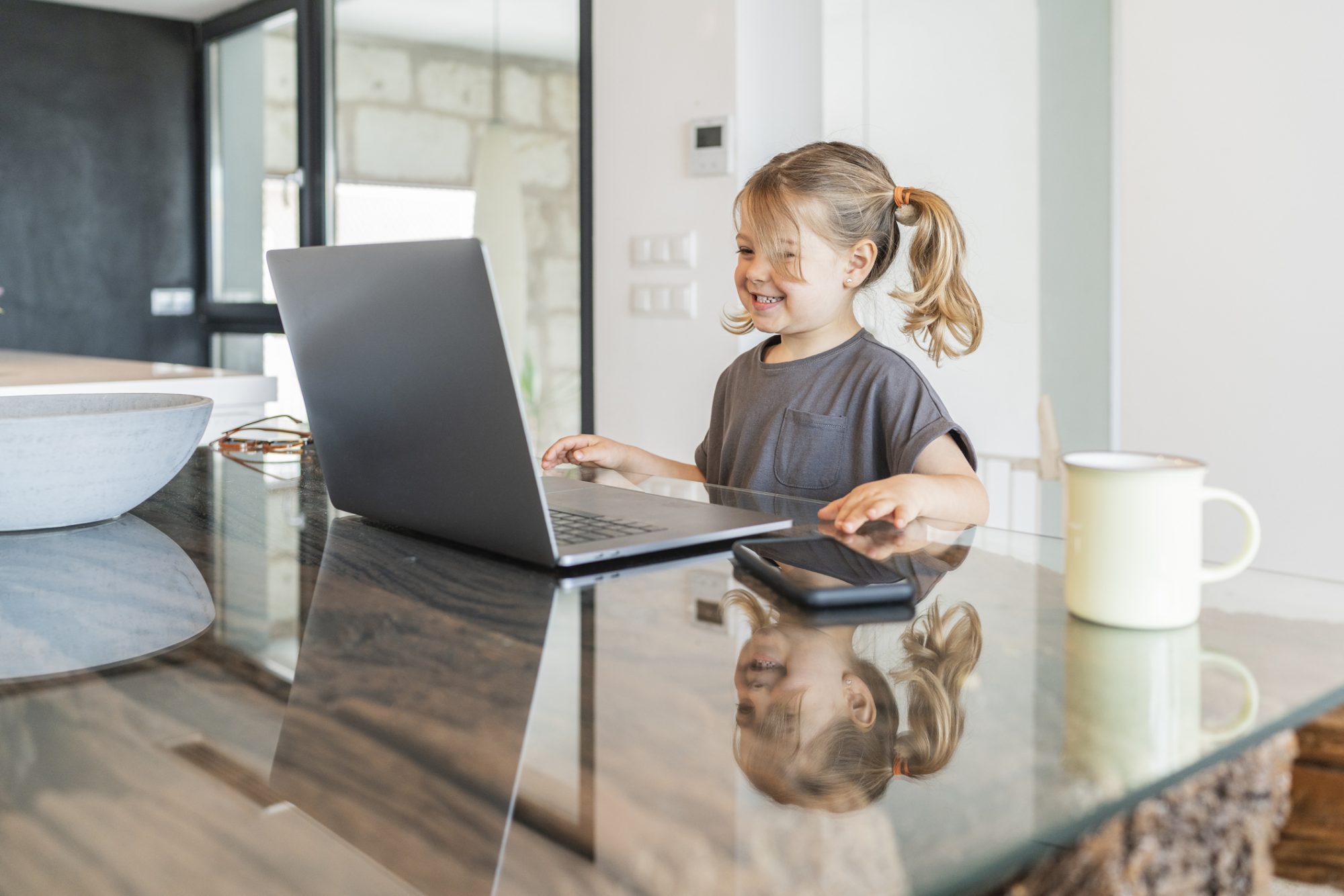 An image of a toddler playing on a computer.