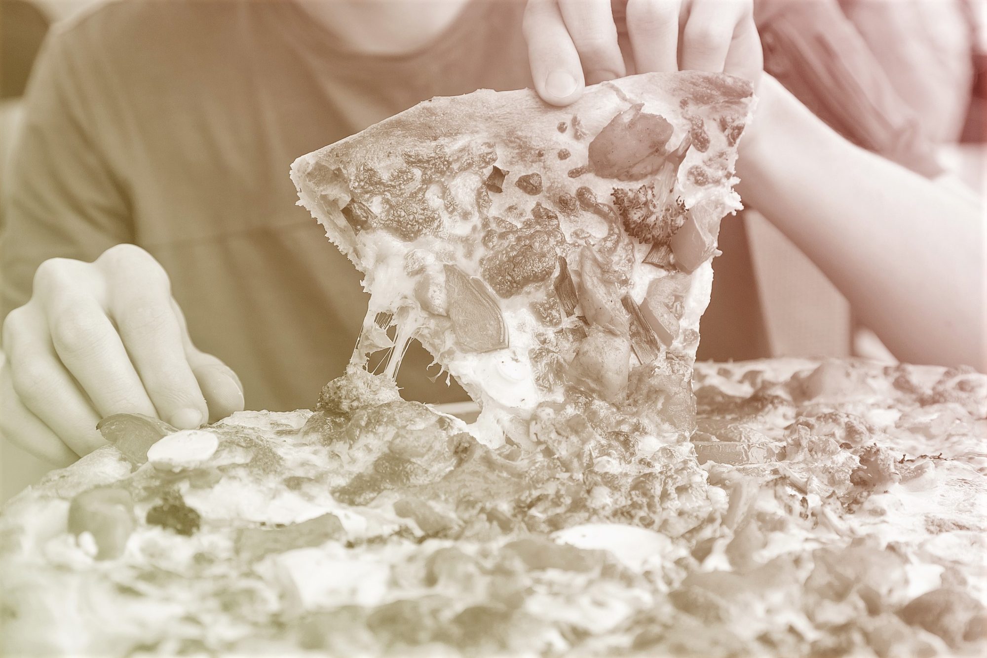 midsection of someone pulling up a slice of pizza