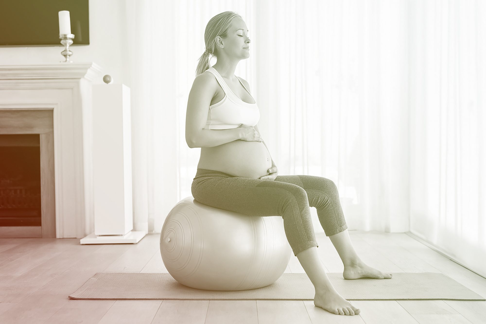 pregnant woman sitting on exercise ball