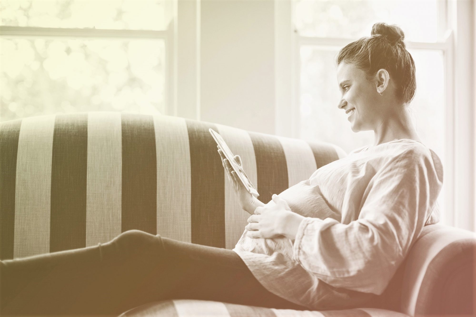 Pregnant female watching movie on digital tablet