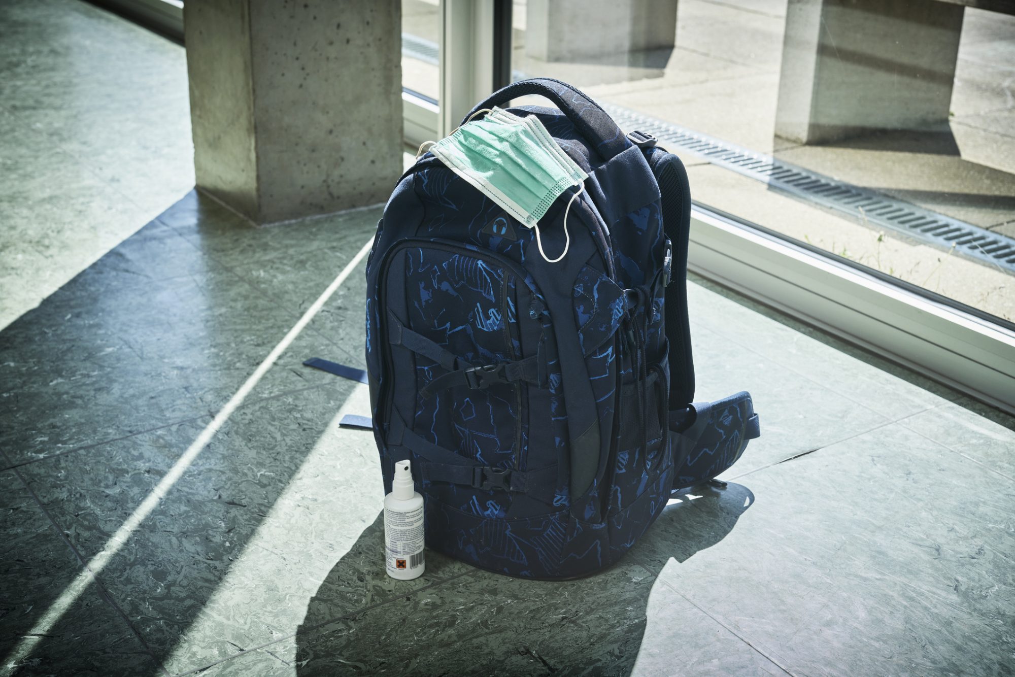 An image of a mask on top of a backpack.