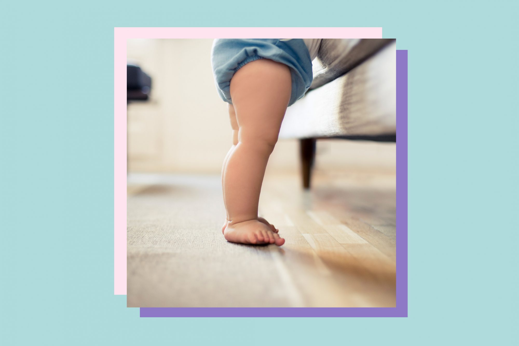An image of a baby standing by a couch.