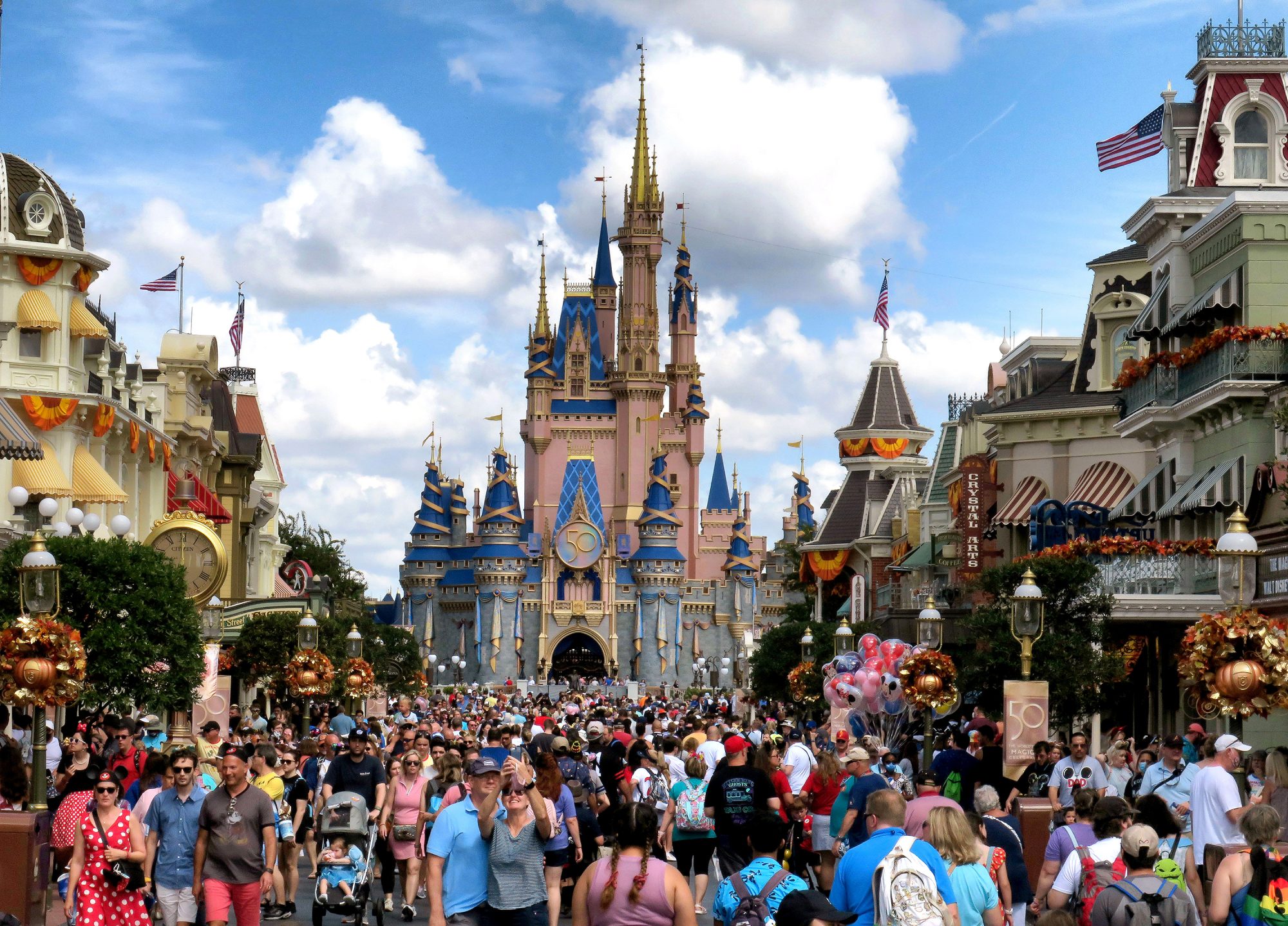 Main Street USA at Disney World filled with crowds with Cinderella's Castle in the background