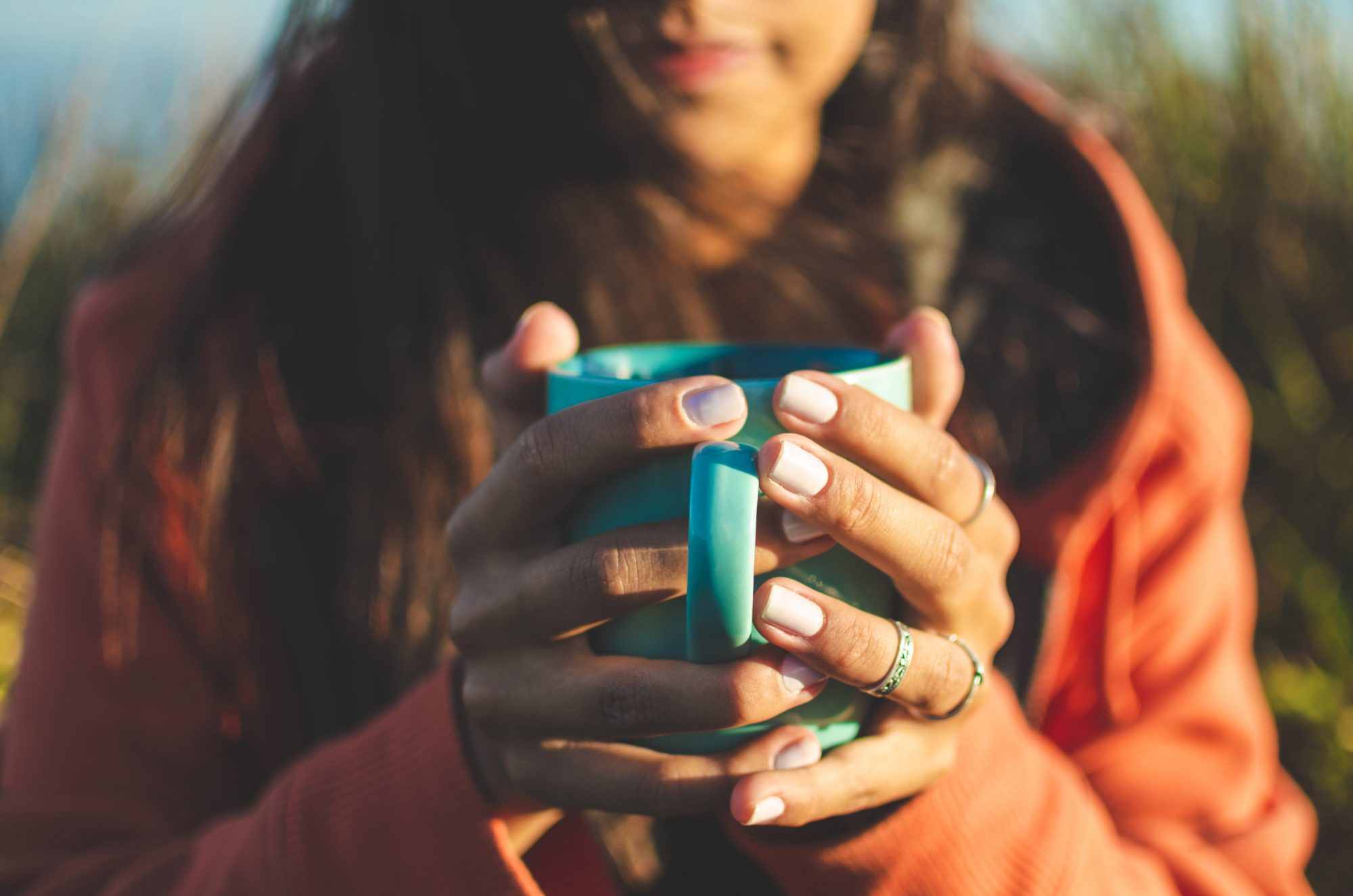 An image of a woman holding a cup of tea.