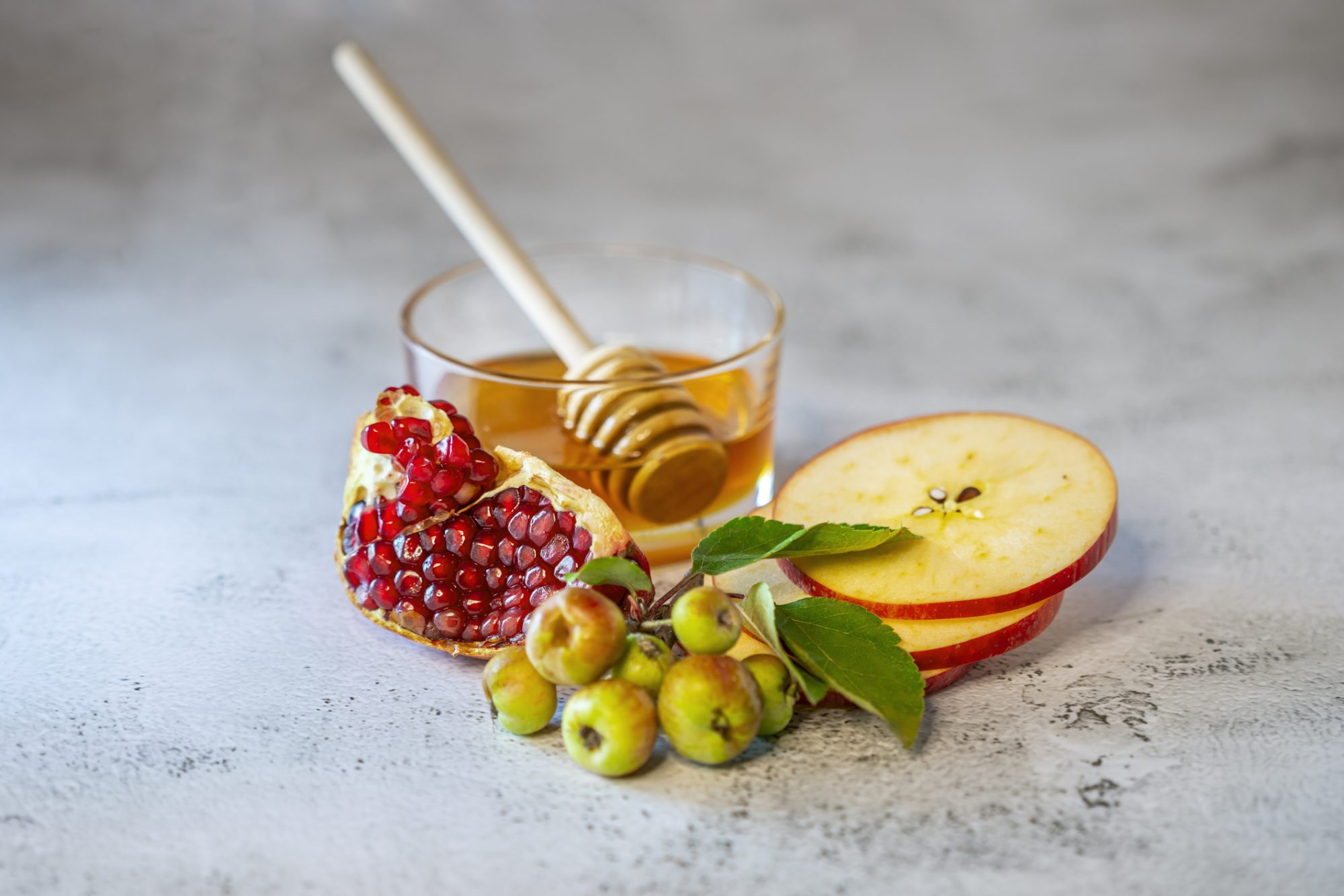 An image of apples, pomegranate, and honey for Rosh Hashanah.