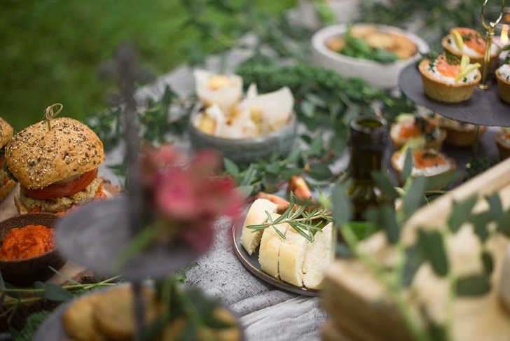 Relaxed outdoor garden party. Buffet table with organic tapas. Fresh baguette bread and tomato.